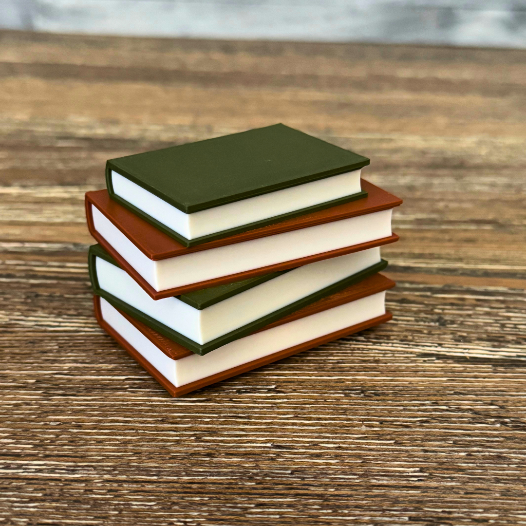 Cozy brown and green light up book stack sitting on a wooden shelf.